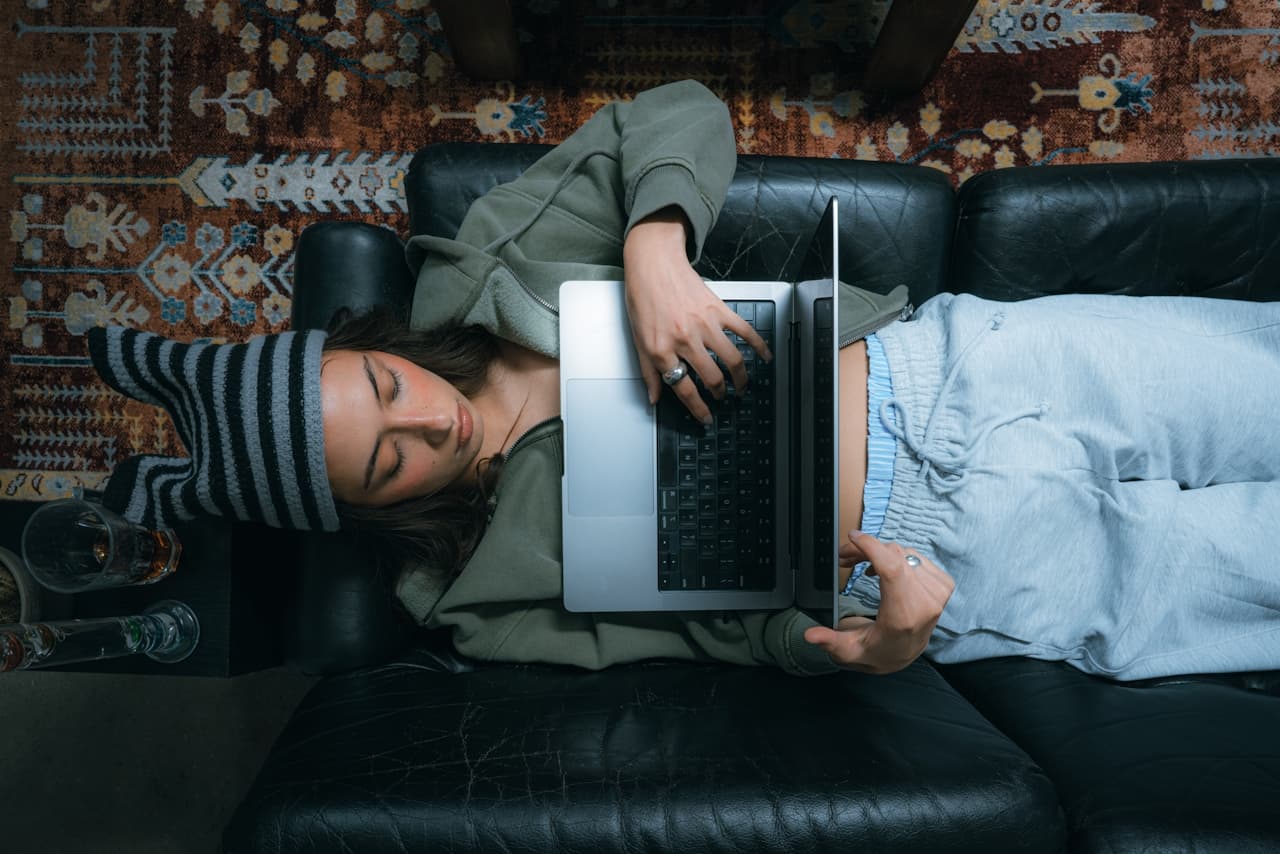 Creator relaxing on sofa with laptop